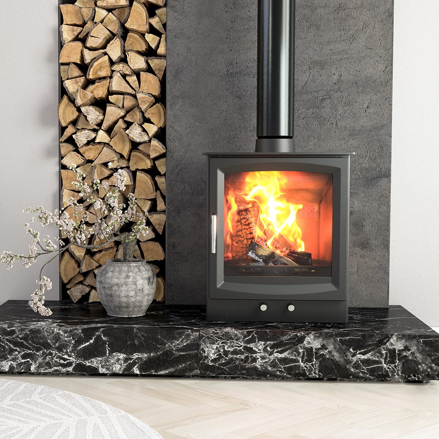 Henley burnbright wood burning stove lit with stack of logs and black marble base