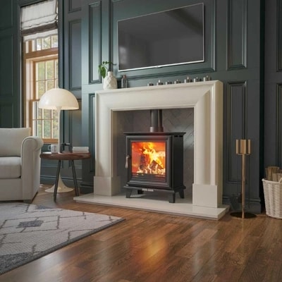 Elmwood wood burning stove lit in lounge with white marble surround